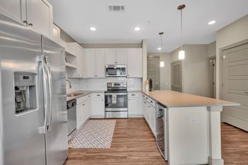 Alton optimist park apartments in charlotte, north carolina model kitchen with hardwood inspired floors